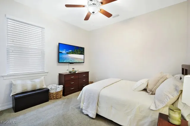 a bedroom with a bed and a flat tv screen on dresser