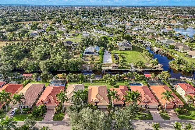 an aerial view of residential houses with outdoor space and trees