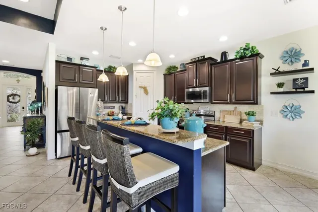 a kitchen with stainless steel appliances granite countertop sink stove top oven and refrigerator