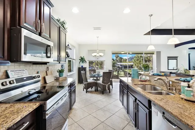 a kitchen with stainless steel appliances granite countertop a sink stove and cabinets