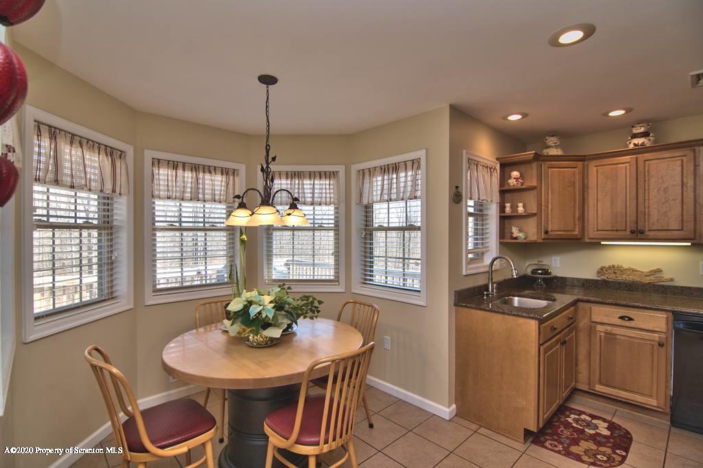 521 Summit Woods Road Moscow, PA 18444 - Photo 19 of 77 a kitchen with stainless steel appliances granite countertop a stove a sink a dining table and chairs