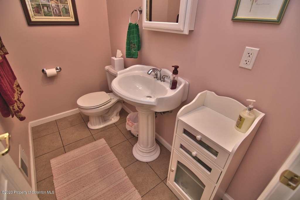 521 Summit Woods Road Moscow, PA 18444 - Photo 30 of 77 a bathroom with a toilet sink and mirror
