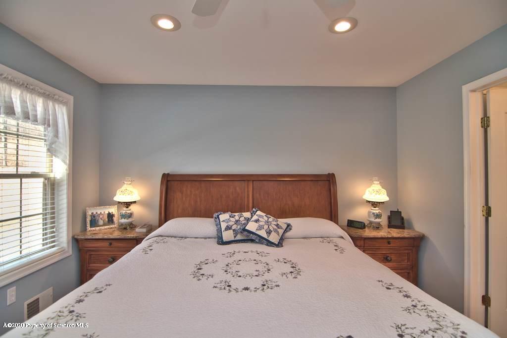 521 Summit Woods Road Moscow, PA 18444 - Photo 33 of 77 a large bedroom with a bed and window