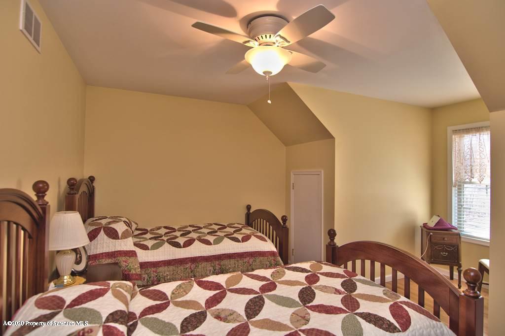 521 Summit Woods Road Moscow, PA 18444 - Photo 48 of 77 a bedroom with a bed and a chandelier