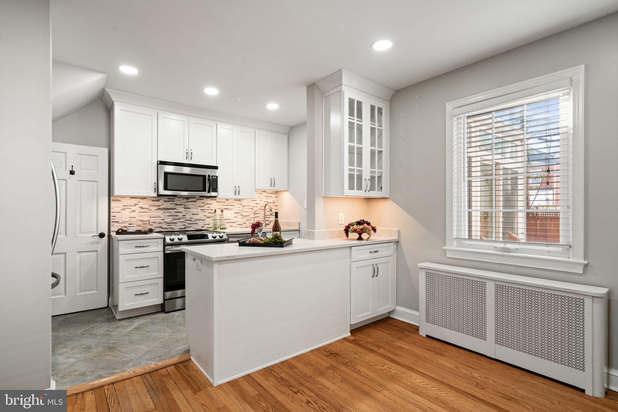 204 South Courthouse Road Arlington, VA 22204 - Photo 15 of 49 a kitchen with stainless steel appliances granite countertop a stove a sink dishwasher a refrigerator and a microwave oven with wooden floor