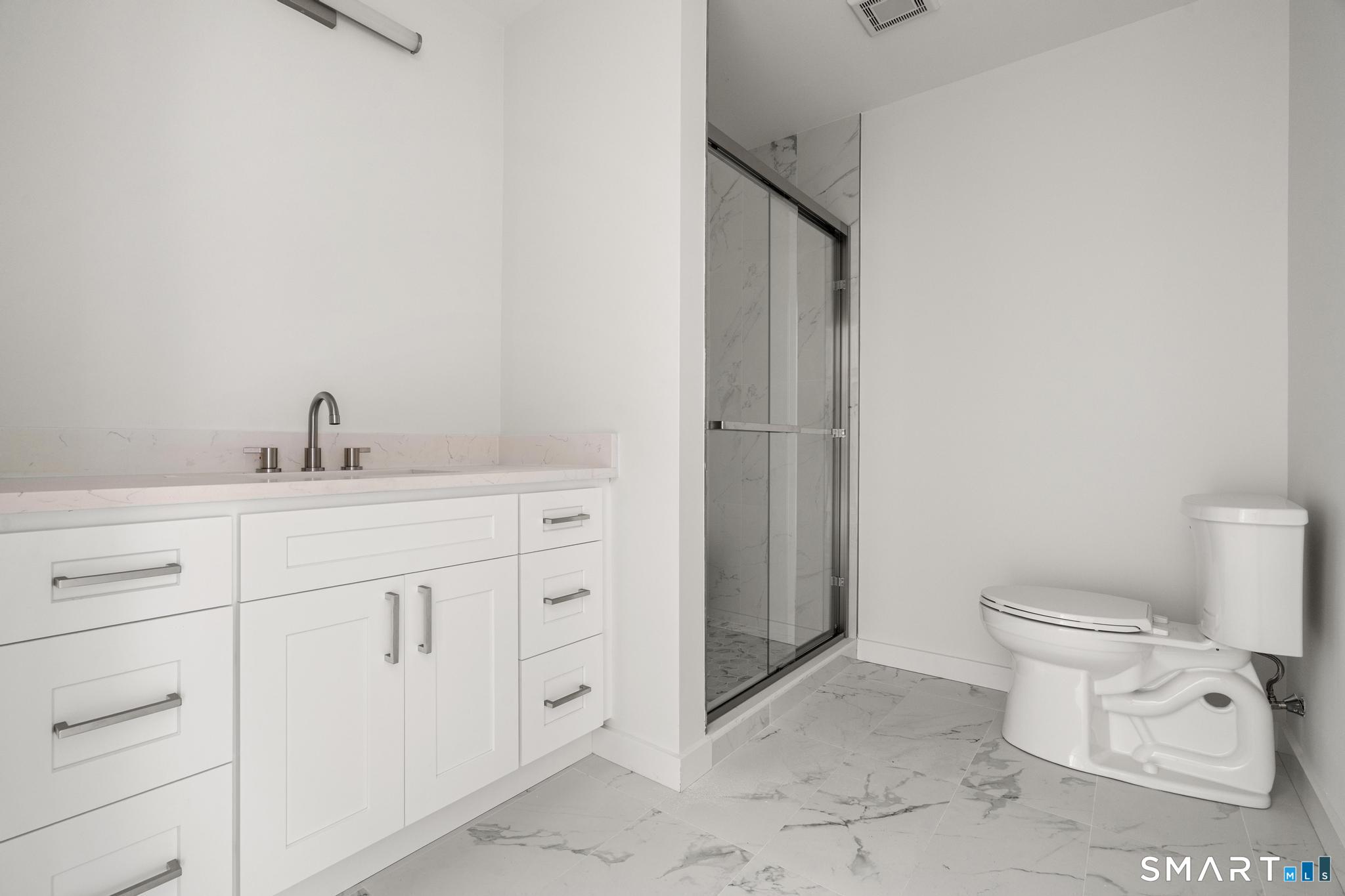 27 Village Road, Unit B Milford, CT 06460 - Photo 12 of 14 a bathroom with a toilet sink and mirror