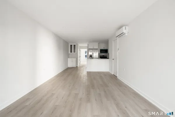 a view of a kitchen with wooden floor and electronic appliances