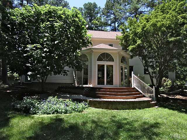 8616 Harbor Drive Raleigh, NC 27615 - Photo 18 of 25 Exterior Back of Home with Mature Trees, Well Maintained Landscaping, Raised Planting Beds, Deck. The Sun Room is the Highlight of the House! Exterior Back