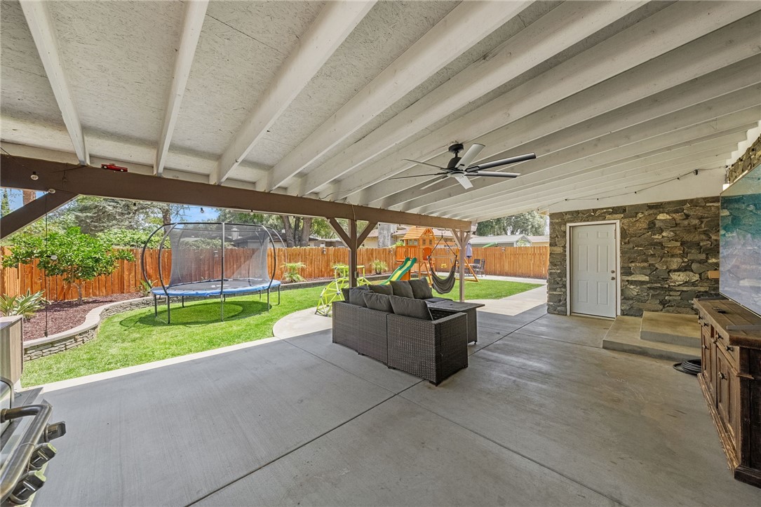 4869 Serrano Place Riverside, CA 92504 - Photo 35 of 40 Family-friendly backyard featuring open lawn space, play equipment, and mature landscaping.