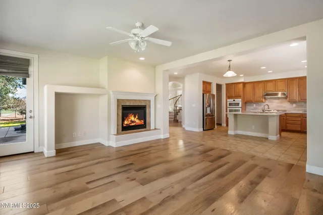 a view of a livingroom with a fireplace a chandelier and wooden floor