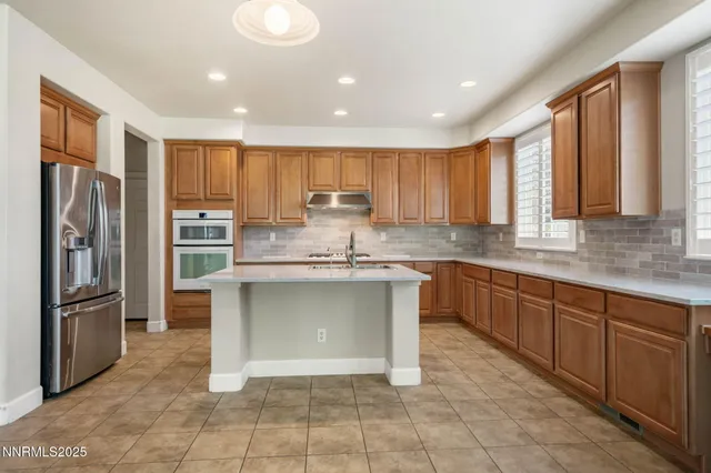 a kitchen with stainless steel appliances granite countertop a refrigerator and a stove top oven