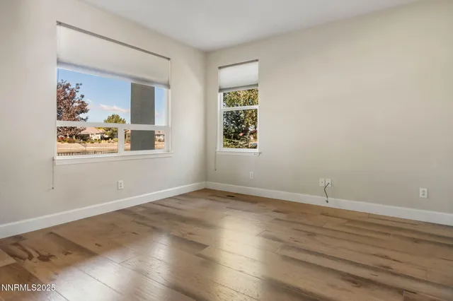 an empty room with wooden floor and window