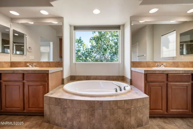 a bathroom with a tub sink and mirror