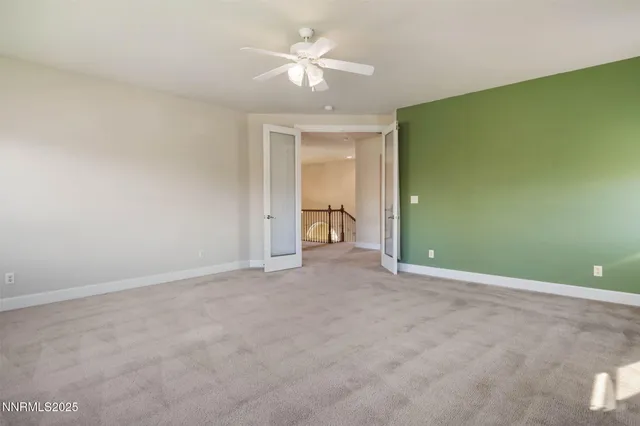 an empty room with a ceiling fan and a window