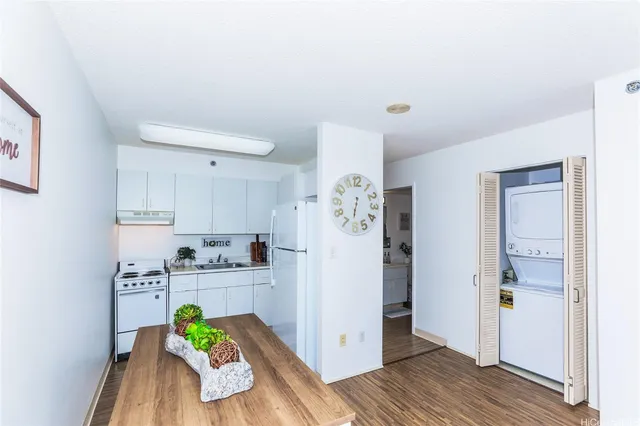 a kitchen with stainless steel appliances kitchen island granite countertop a refrigerator and a stove top oven