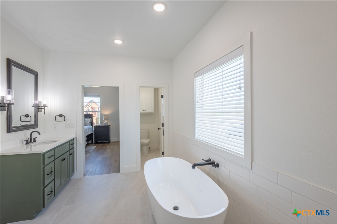 4324 Cedar Creek Road Temple, TX 76504 - Photo 19 of 45 a en suite bathroom with a double vanity sink a mirror and a bathtub