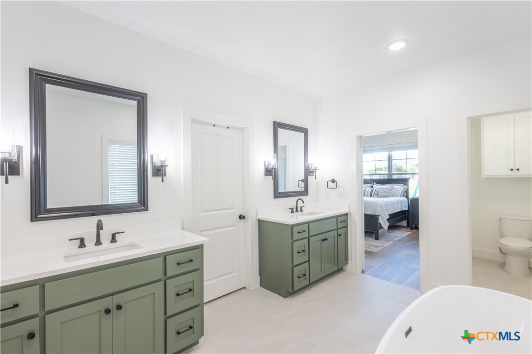 4324 Cedar Creek Road Temple, TX 76504 - Photo 20 of 45 a spacious bathroom with a double vanity sink a mirror and a toilet