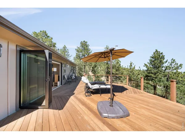 a patio with wooden floor a yard a table and chairs