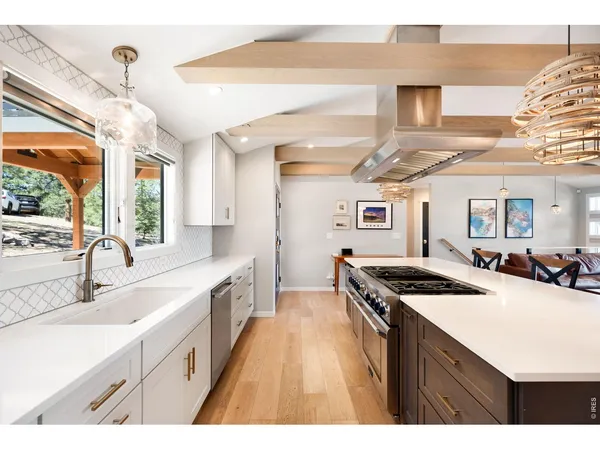a kitchen with a stove a kitchen island a dining table and chairs with wooden floor