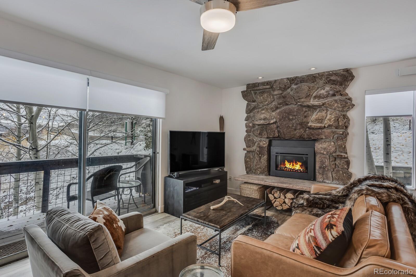 a living room with furniture a flat screen tv and a fireplace