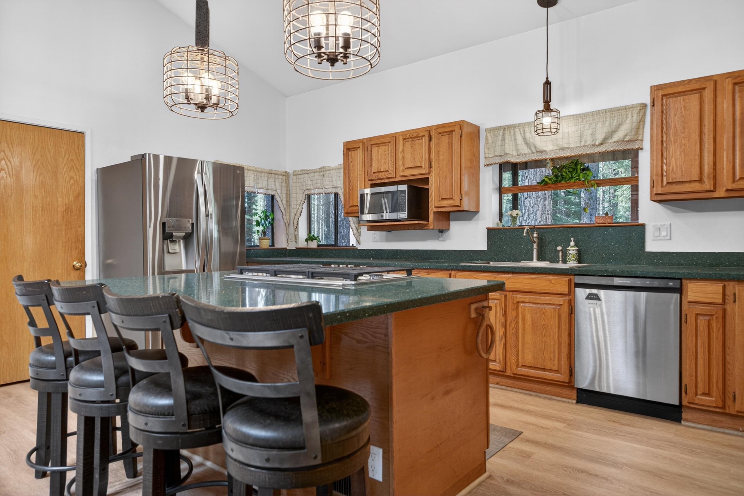 463-000 Moonlight Ranch Rd Westwood Road Susanville, CA 96130 - Photo 4 of 46 a kitchen with stainless steel appliances a table chairs and a refrigerator