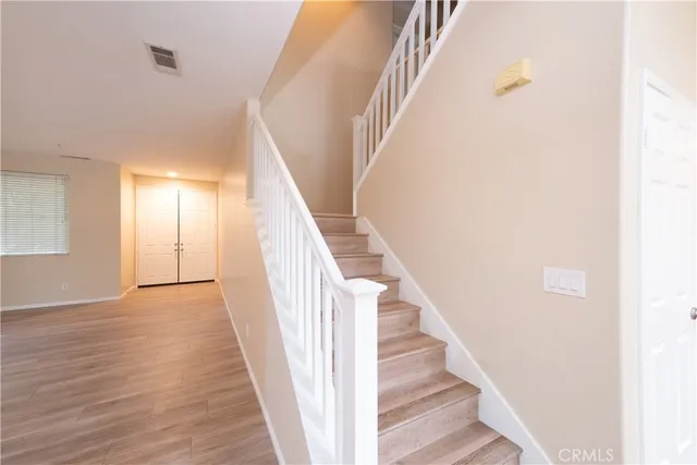 a view of a hallway with wooden floor and staircase