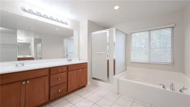 a spacious bathroom with a tub sink shower and mirror