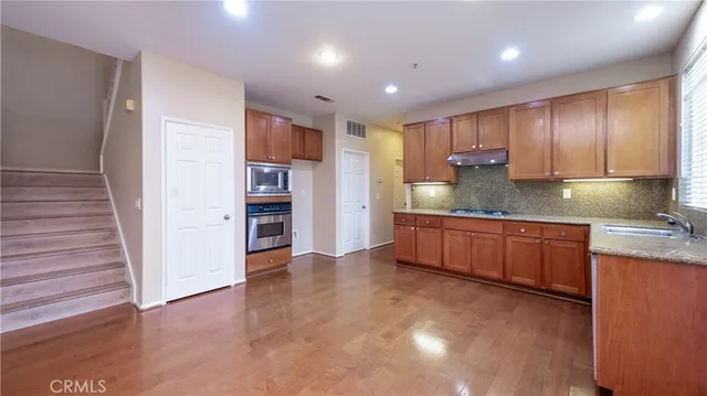 a kitchen with stainless steel appliances granite countertop a sink and cabinets