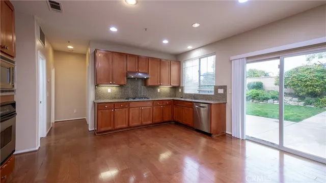 a kitchen with a sink a counter top space and stainless steel appliances