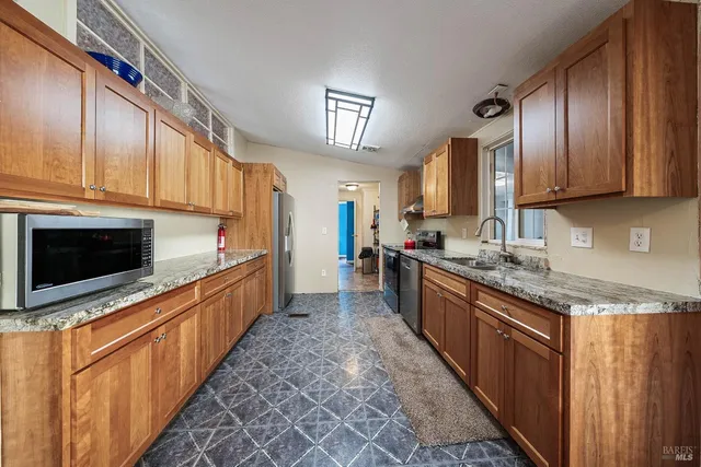 a kitchen with stainless steel appliances granite countertop a stove sink and cabinets