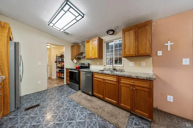 a kitchen with stainless steel appliances a stove a refrigerator and cabinets