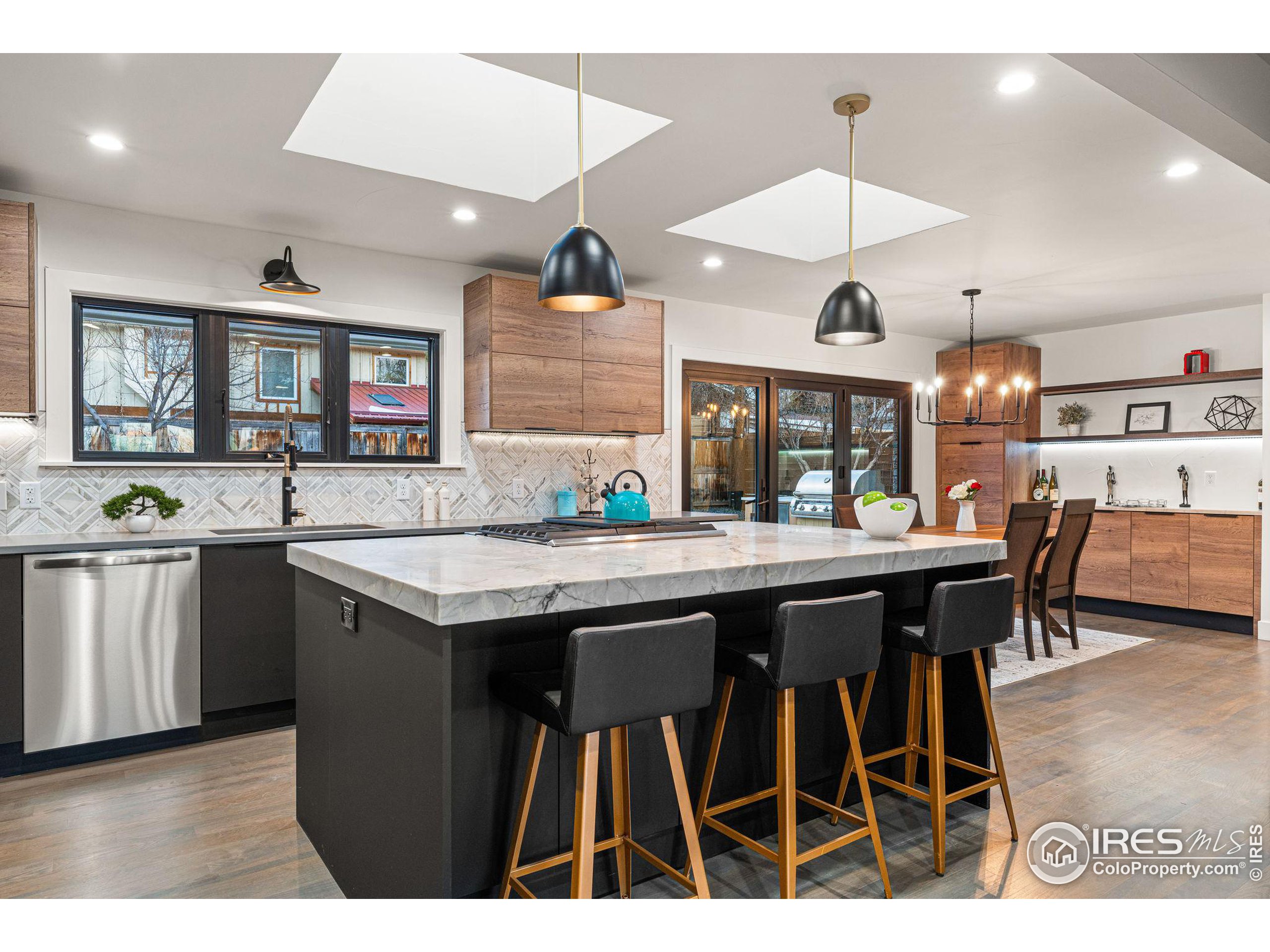 a kitchen with stainless steel appliances granite countertop a stove a sink a dining table and chairs