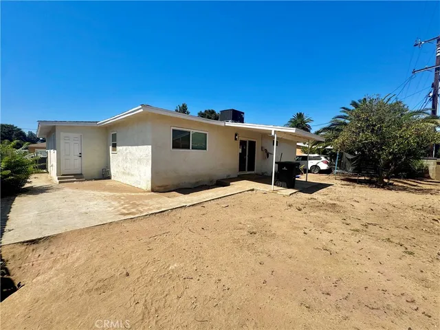 a view of house with swimming pool and sitting area