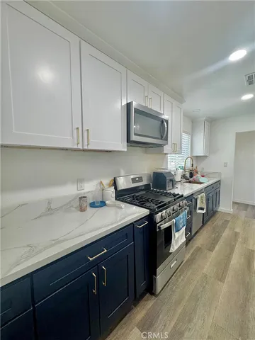 a kitchen with stainless steel appliances granite countertop a sink a stove and a microwave