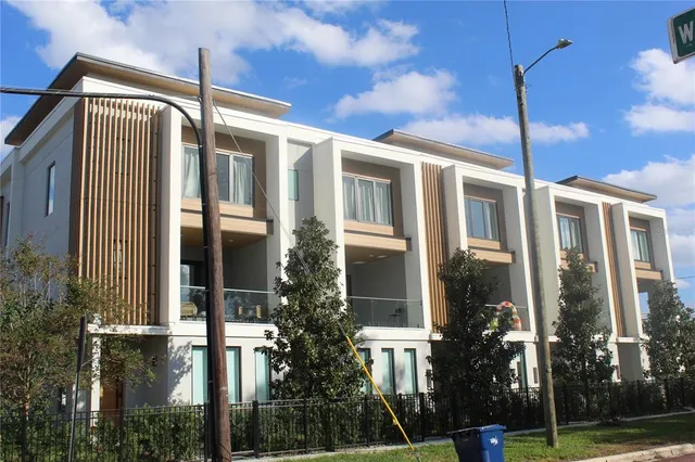a front view of multi story residential apartment building with retail shops