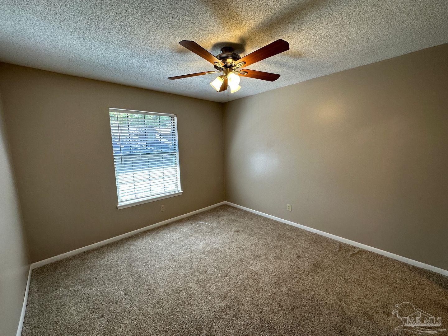 4831 East Olive Road, Unit 4D Pensacola, FL 32514 - Photo 10 of 17 an empty room with windows and fan