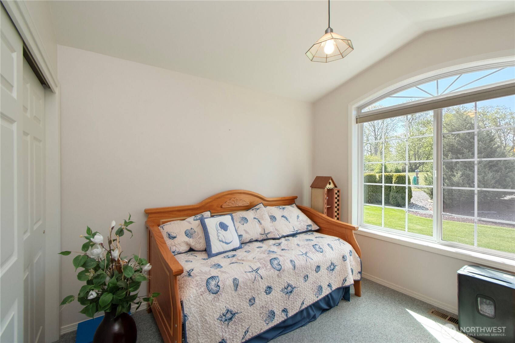 23 Pearl Place Sequim, WA 98382 - Photo 16 of 40 a bedroom with a bed a chandelier and a window