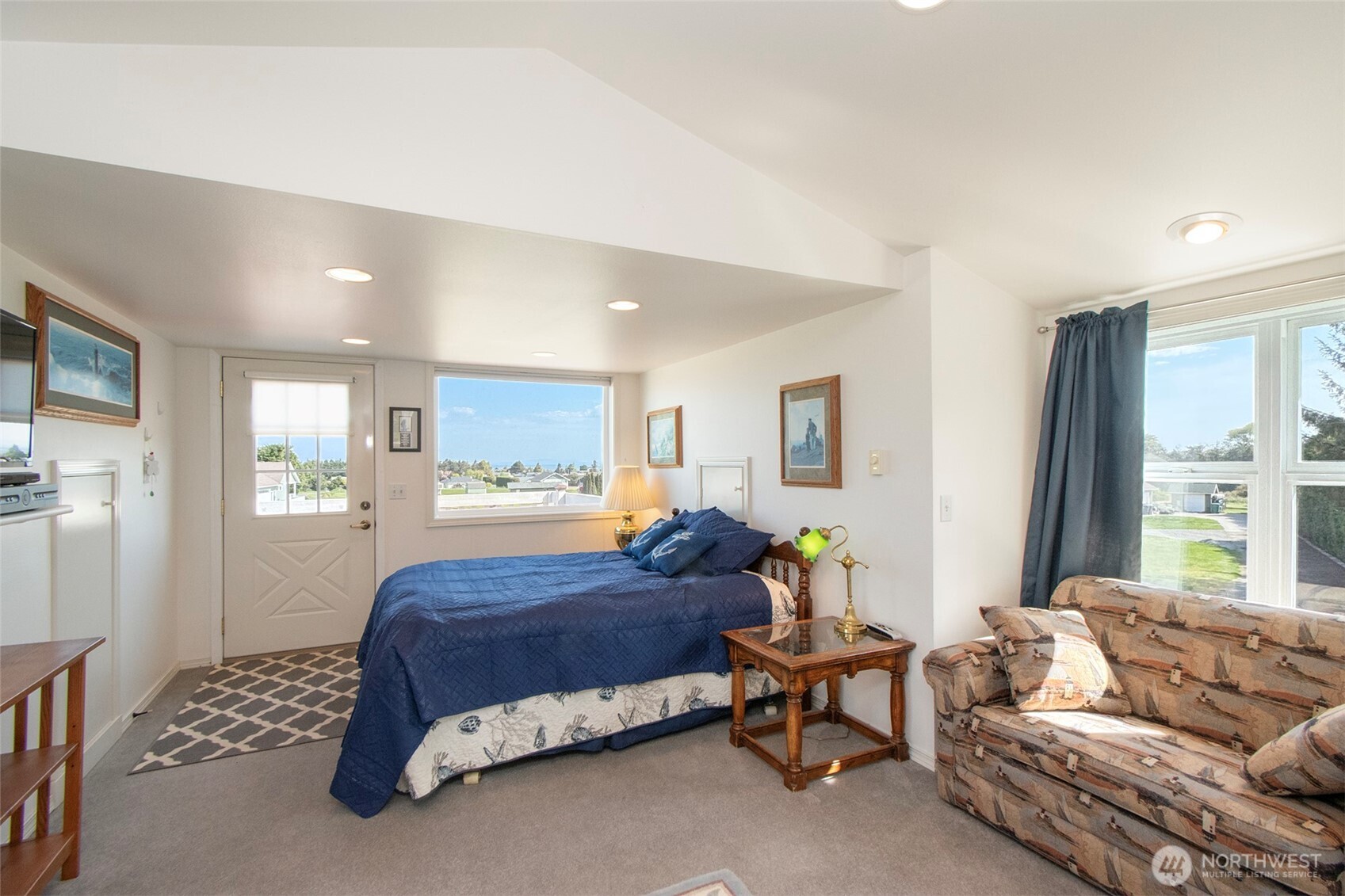 23 Pearl Place Sequim, WA 98382 - Photo 35 of 40 a spacious bedroom with a bed a couch and a window with wooden floor