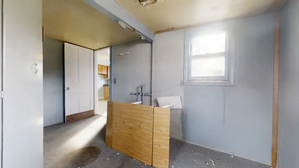 an empty room with windows and ceiling fan