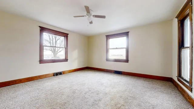 a view of an empty room with a ceiling fan