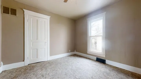 an empty room with windows and closet