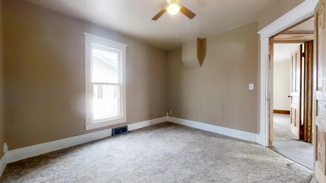 an empty room with fan and entrance