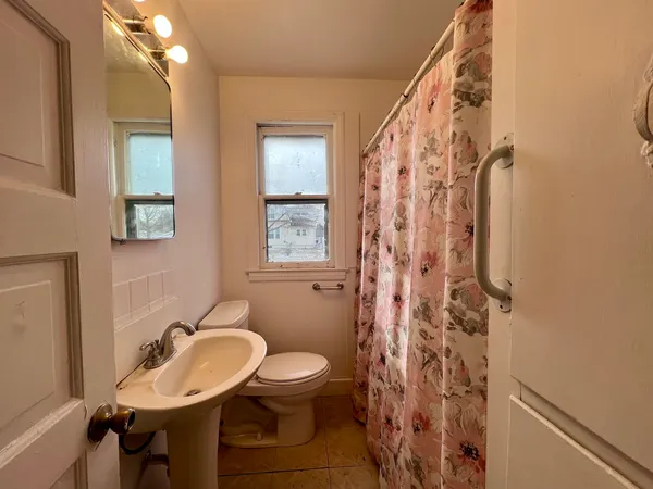 a bathroom with a toilet a sink and mirror