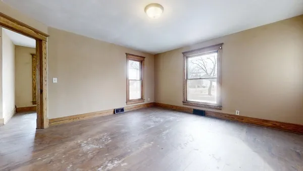 an empty room with windows and closet