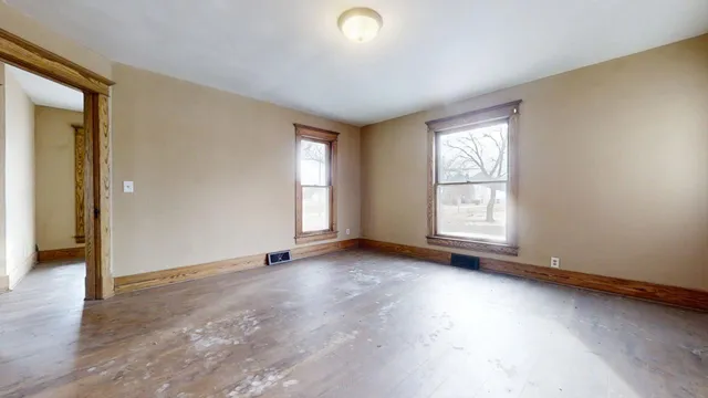 an empty room with windows and closet