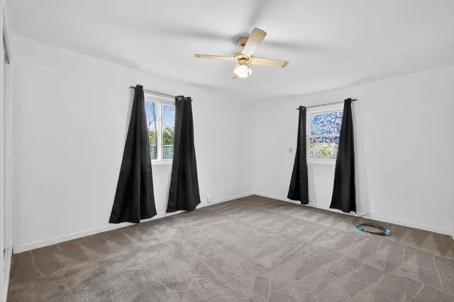 a view of an empty room with a chandelier fan