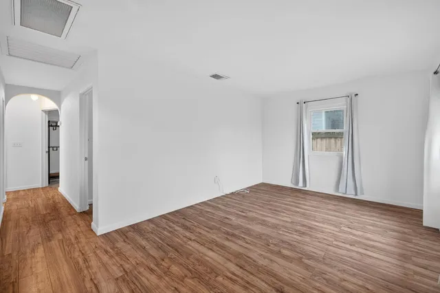 a view of empty room with wooden floor