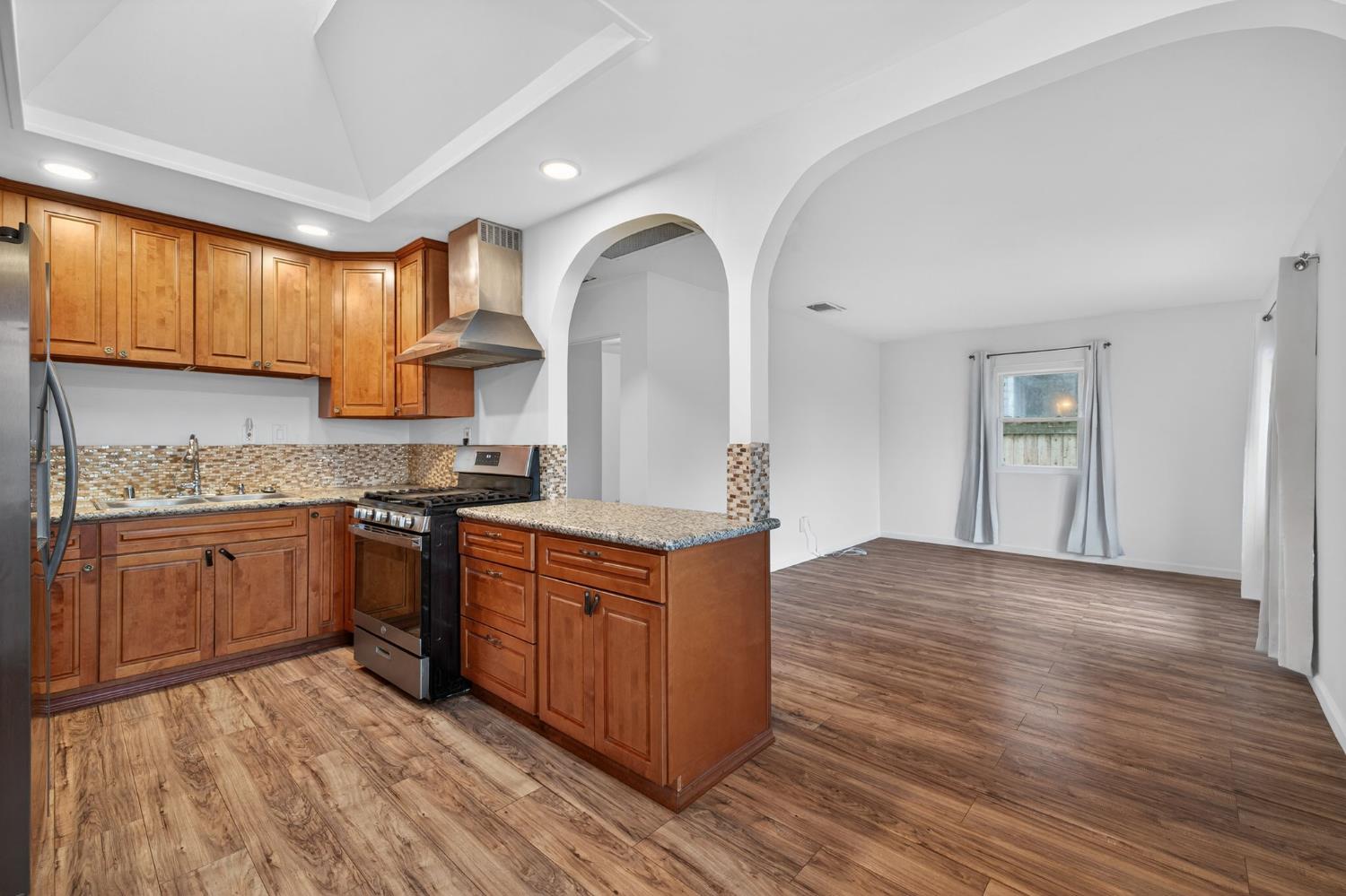 2812 Plover Street Sacramento, CA 95815 - Photo 10 of 40 a kitchen with stainless steel appliances granite countertop a stove a sink dishwasher and a refrigerator with wooden floor