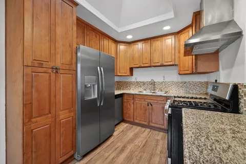 a kitchen with stainless steel appliances granite countertop a refrigerator a sink and dishwasher