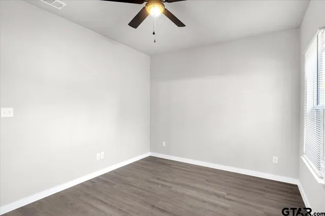 an empty room with a window and wooden floor